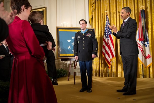 President Barack Obama applauds as Staff Sergeant Clinton Romesha looks over at his wife and children after receiving the Medal of Honor during the award ceremony in the East Room of the White House, Feb. 11, 2013. (Official White House Photo by Pete Souza)