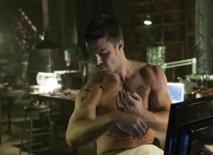 Stephen Amell as Oliver Queen stitching up his injuries