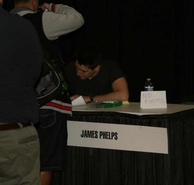 James Phelps signs for a fan as the small "No Photo" sign serves as a reminder to those in the area to follow the MegaCon order to meet and greet the guests.