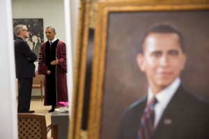 President Barack Obama is reflected in a mirror as he talks with Chief of Staff Denis McDonough prior to participating in the commencement ceremony at Morehouse College in Atlanta, Ga., May 19, 2013. A painting of the President stands in the foreground. (Official White House Photo by Pete Souza)