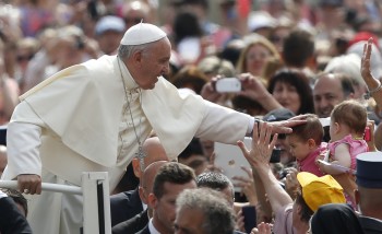Pope Francis greets a baby as he arrives to lead his general audience in St. Peter's Square at the Vatican May 20. (CNS photo/Paul Haring) May 20, 2015. photo courtesy of USCCB