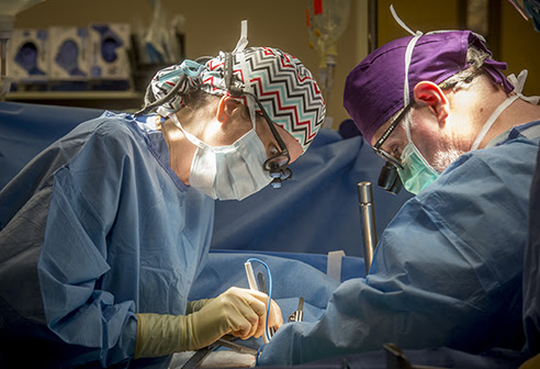 Dr. Jayme Locke, MD (Assistant Professor, Surgery - Transplantation) and Dr. Mark Deierhoi, MD (Professor, Surgery - Transplantation) are performing 50th UAB Kidney Chain surgery in operating room, 2015.